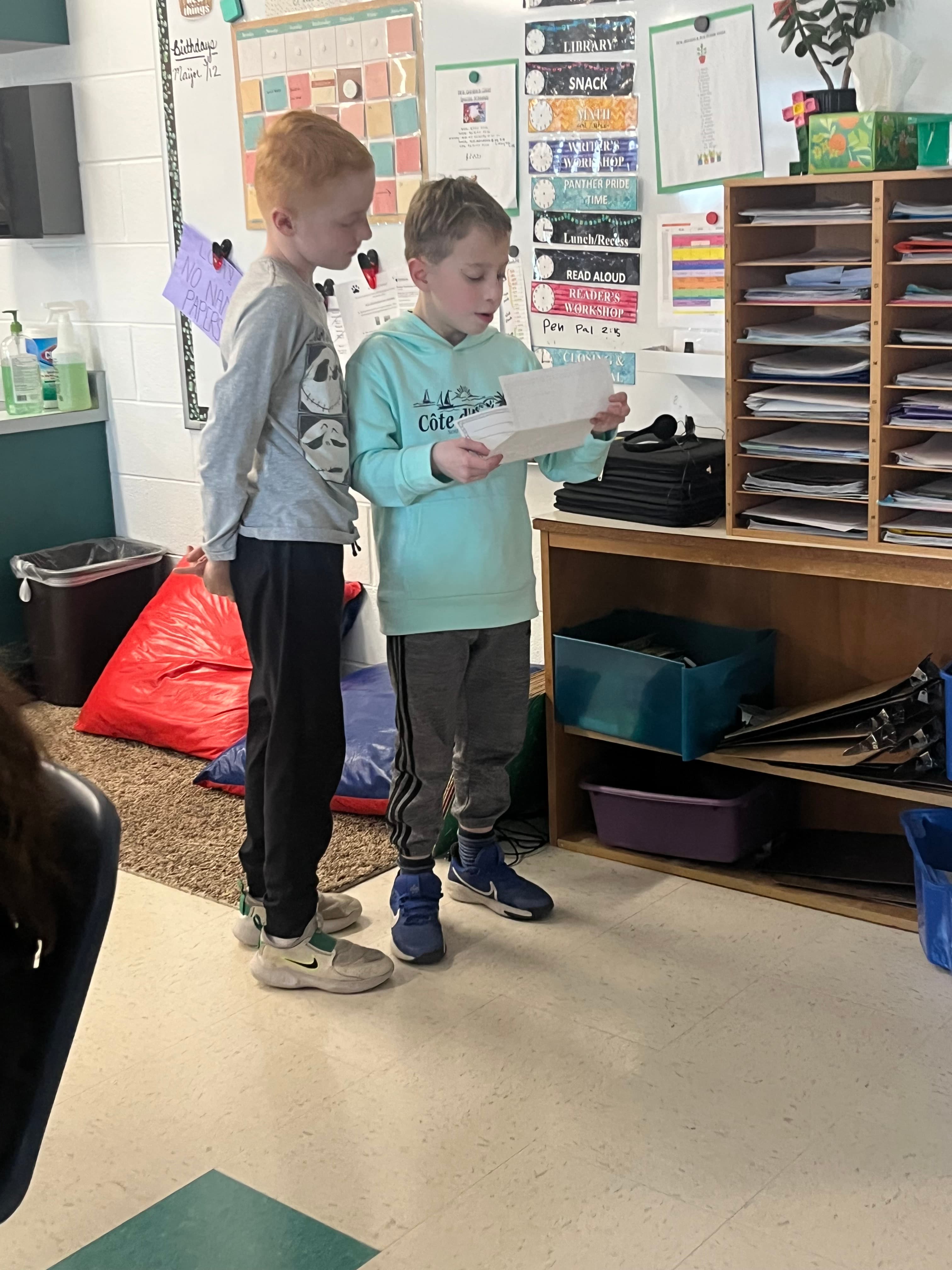Two kids reading a letter together