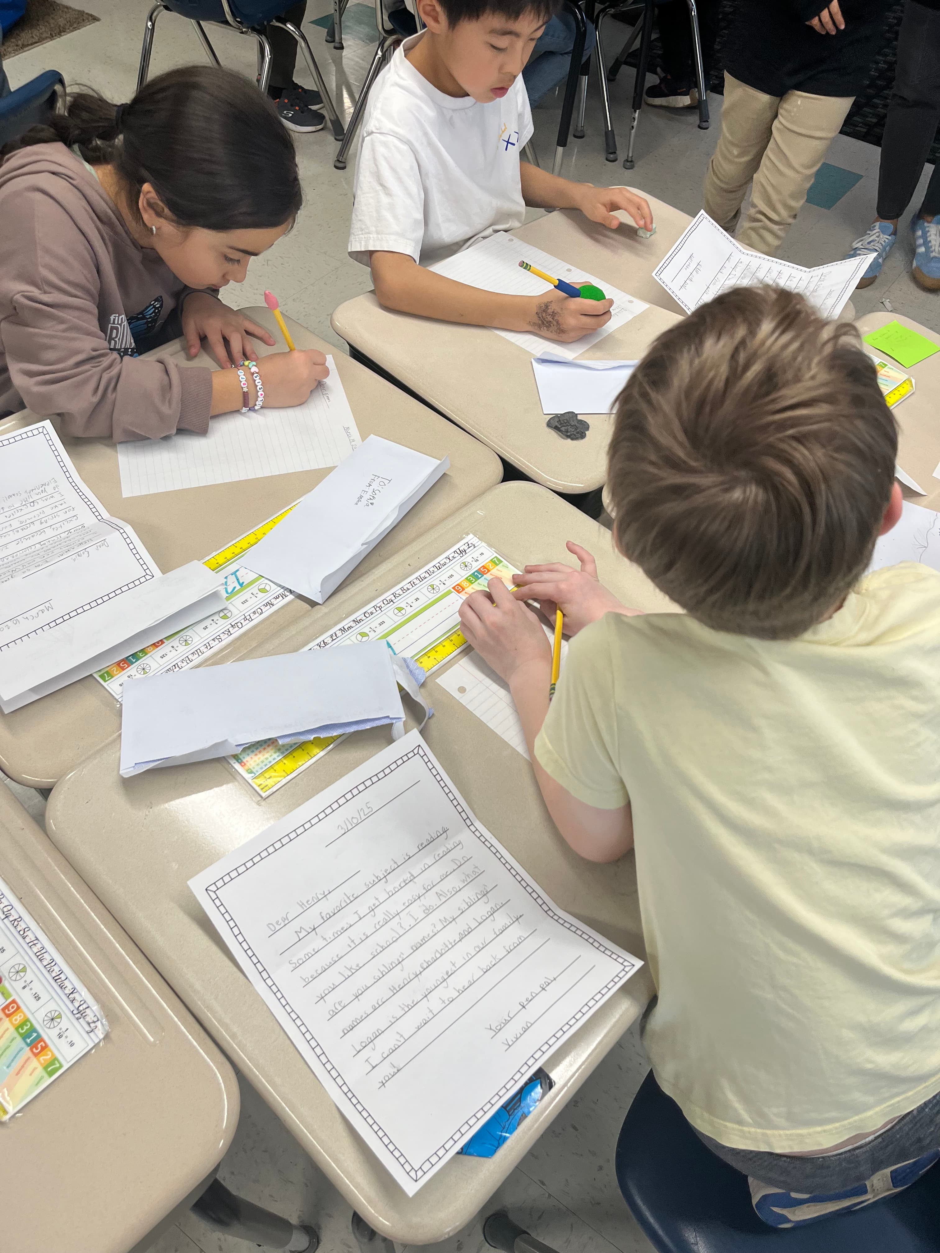Kids writing letters at their desks, overhead view