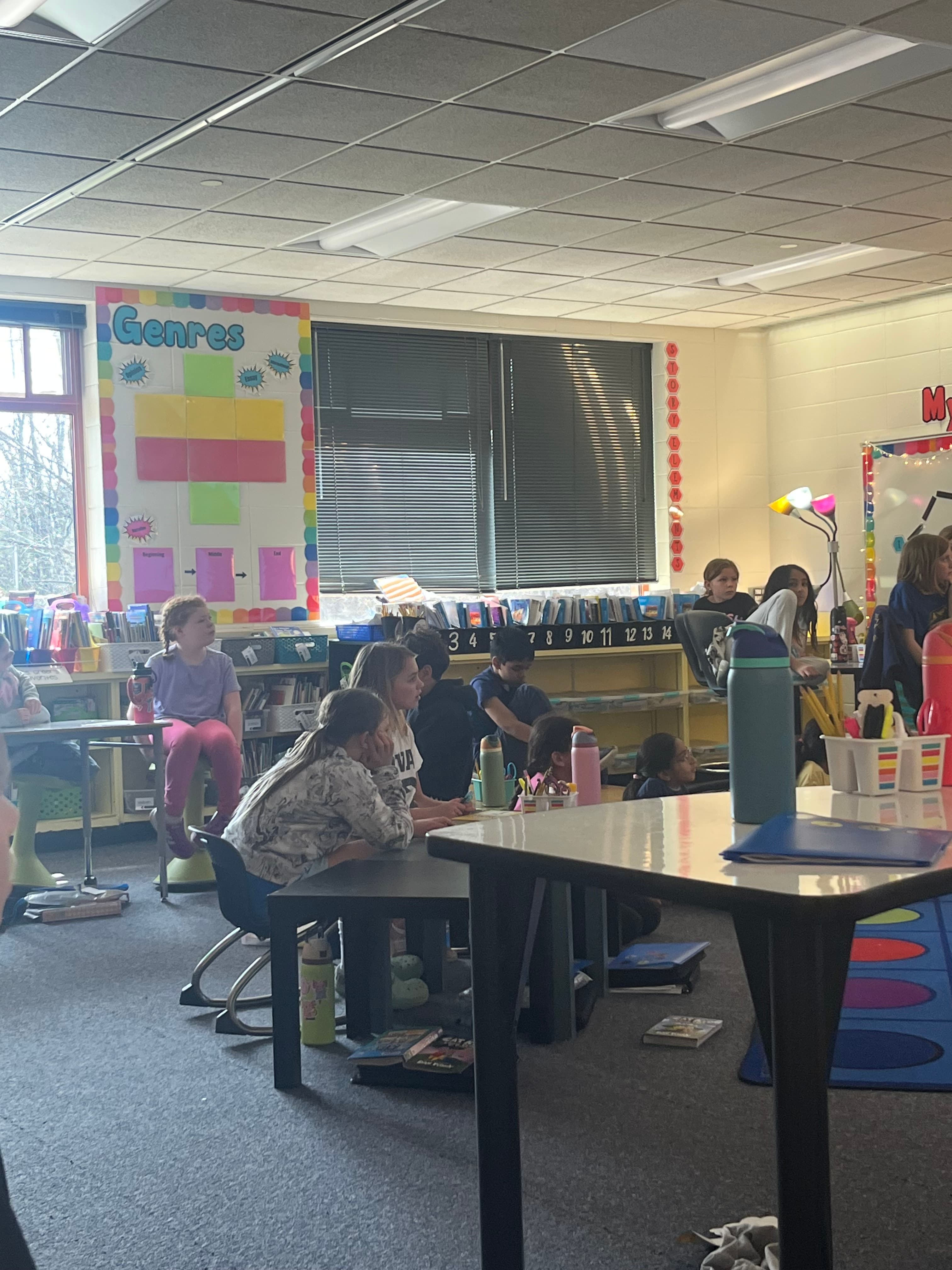 Kids at round table writing overhead